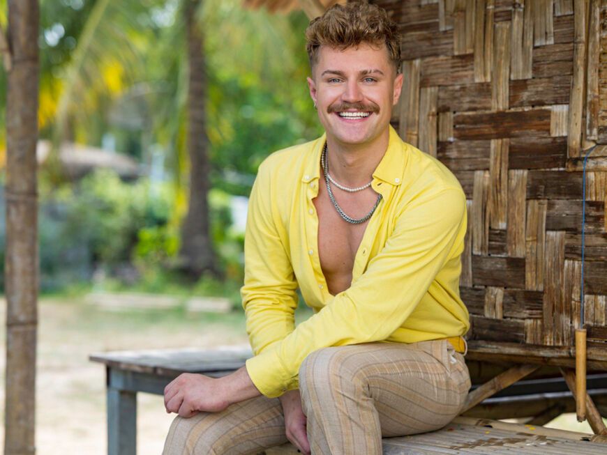 "Charming Boys"-Kandidat Aaron Königs lächelt am Strand