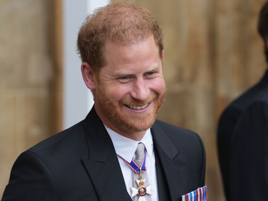 Prinz Harry lächelt bei der Krönung von Charles