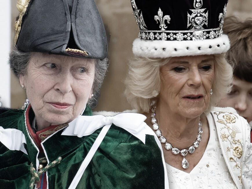 Prinzessin Anne guckt mit Hut skeptisch zur Seite, Königin Camilla guckt mit Krone nach unten
