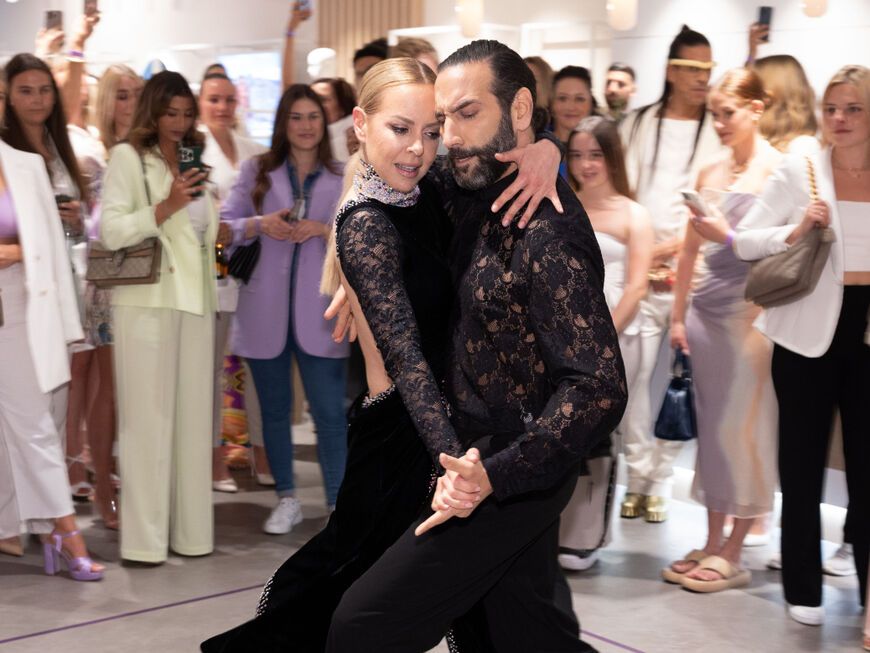 Isabel Edvardsson und Massimo Sinató tanzen in Modegeschäft