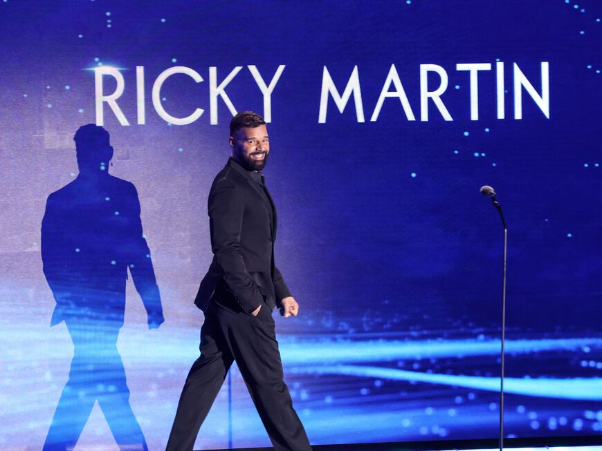Ricky Martin geht über die Bühne, auf einem Bildschirm steht sein Name