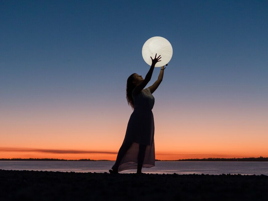 Frau hält Mond in den Händen