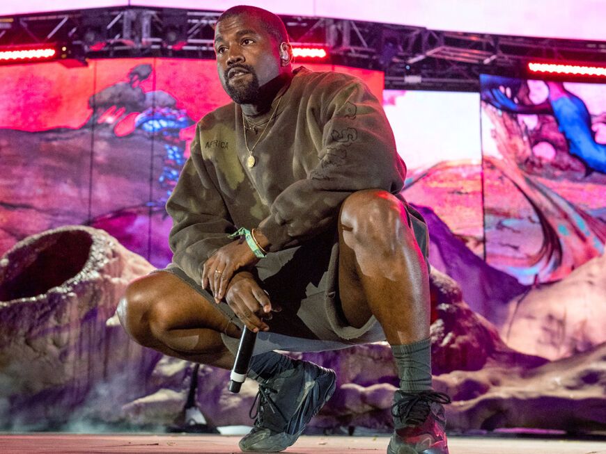 Kanye West hockt auf der Bühne