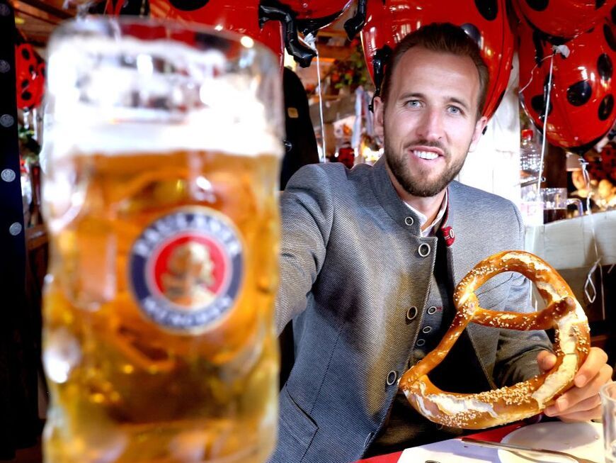 Harry Kane vom FC Bayern München posiert mit Maß Bier und Brezen auf dem Oktoberfest 2023 