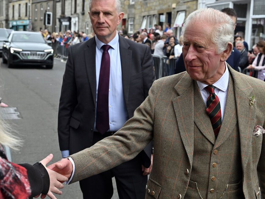 König Charles III. Schottland, er schüttelt einer Frau die Hand.