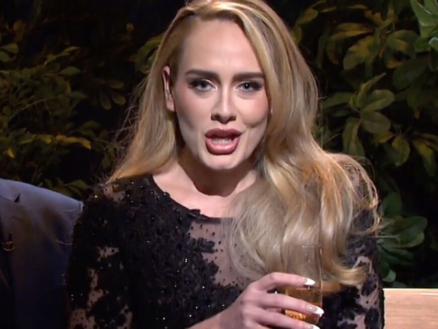 Adele spricht mit Drink in der Hand