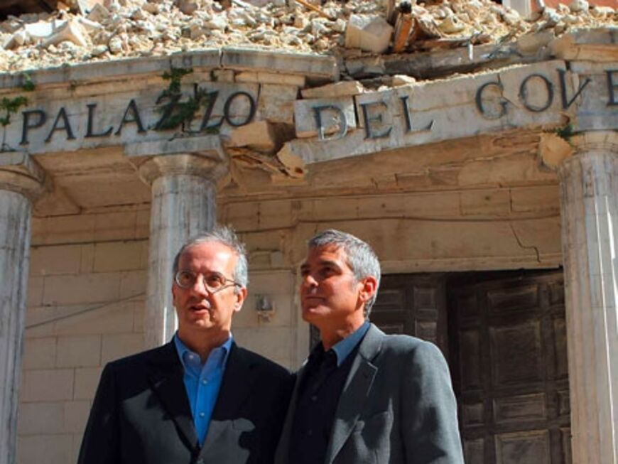Schriftsteller Walter Veltroni und George Clooney stehen vor einem zerstÃ¶rten GebÃ¤ude. Hunderte Menschen in L´´Aquila sind noch obdachlos