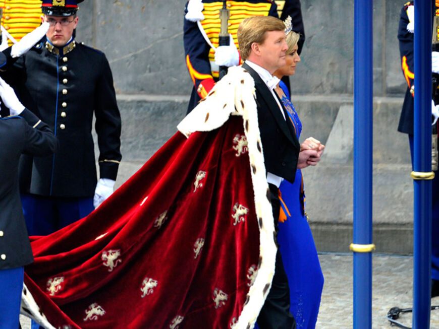 König Willem-Alexander trägt einen traditionellen, mit Hermelin verzierten Mantel. Máxima wählte ein königsblaues Kleid mit einem großen mit Diamanten besetzten Diadem, welches König Willem III einst für seine Frau, Königin Emma, anfertigen ließ