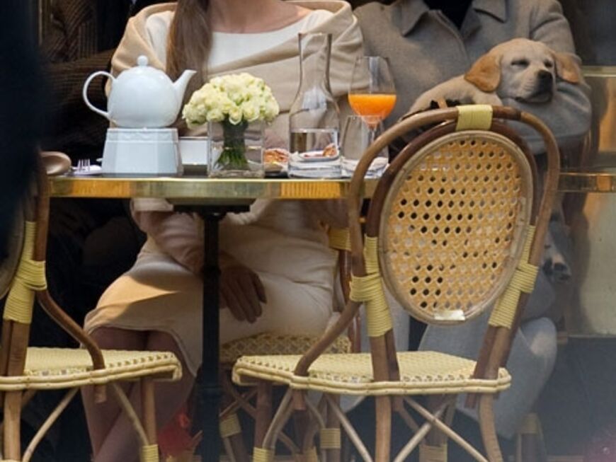 Lady-like und mit ärmelhohen Wildlederhandschuhen: Angelina Jolie sitzt in einem Pariser Café beim Petit-Déjeuner