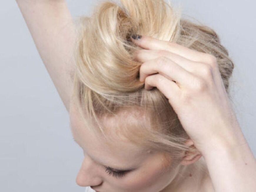 Step 3: Volumenspray in die Längen geben und alle Haare kräftig toupieren. Strähnen zusätzlich mit den Fingern aufbauschen und zu einer großen fluffigen Schnecke drehen. Wichtig 
ist, dass der Knoten locker und nicht zu streng sitzt. Die Enden einfach innen verstecken