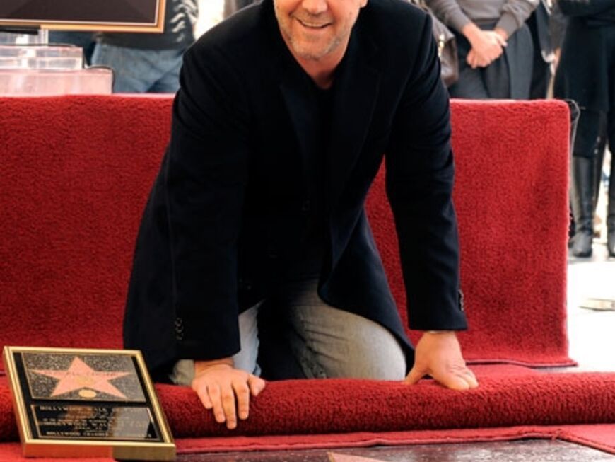 Der 46-jährige Oscar-Preisträger Crowe kniet stolz vor seinem Stern. "Gleich neben Sir Anthony Hopkins, das ist kein schlechter Platz", freut er sich
