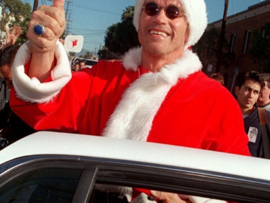 Schauspieler und Gouverneur Arnold Schwarzenegger posiert lässig im Santa Claus-Outfit