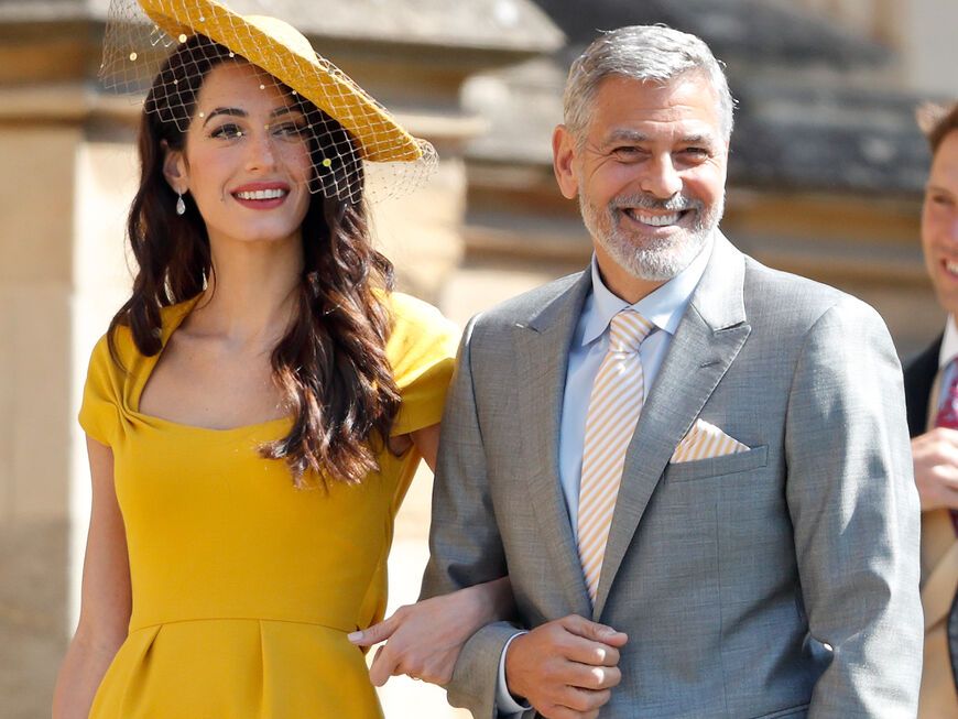 George Clooney und Amal Clooney strahlen.