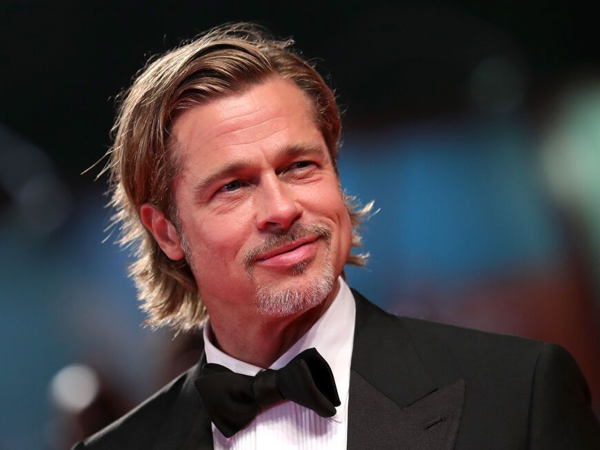 Brad Pitt lächelt und trägt einen Anzug