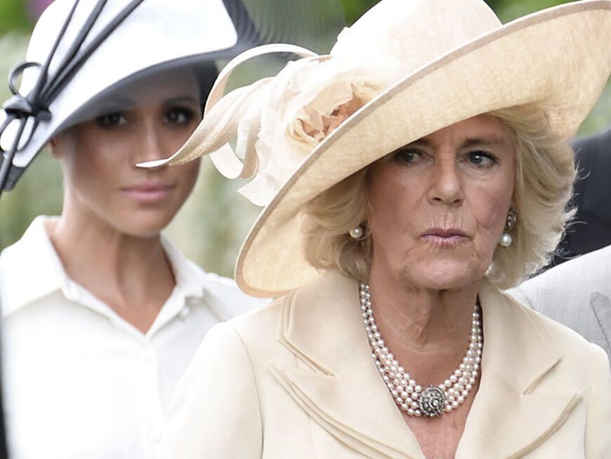Herzogin Meghan und Queen Consort Camilla nebeneinander und ernst