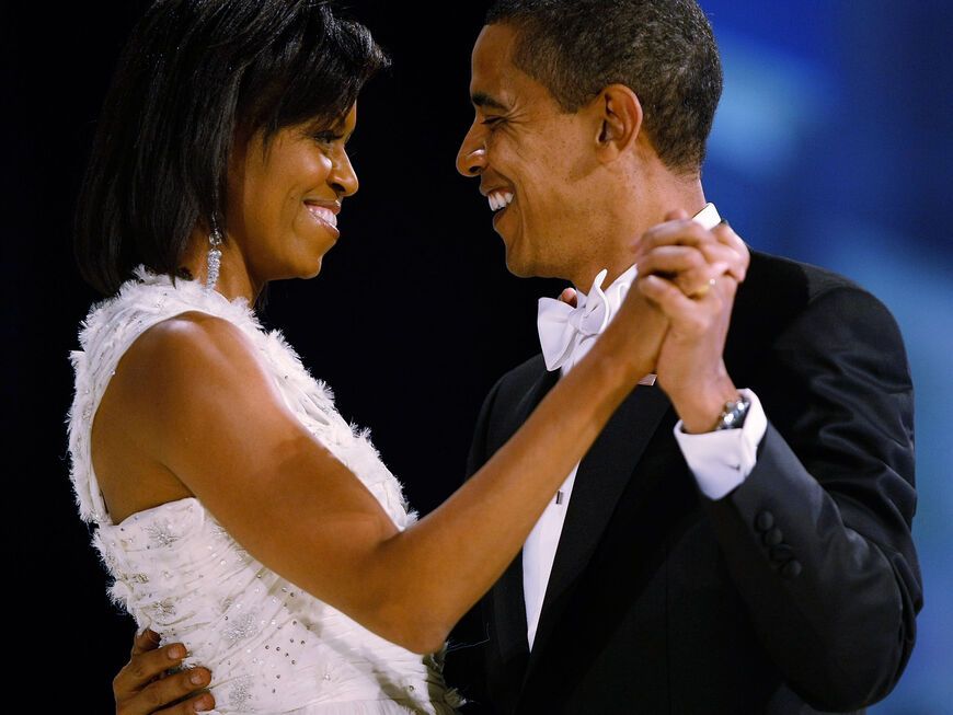 Michelle und Barack Obama tanzen und gucken sich verliebt an.