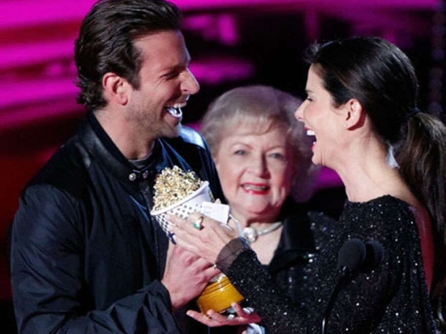 Bradley Cooper überreicht der Schauspielerin die MTV Popcorn-Tüte. Vom Publikum bekam sie für ihren Auftritt Standing Ovations