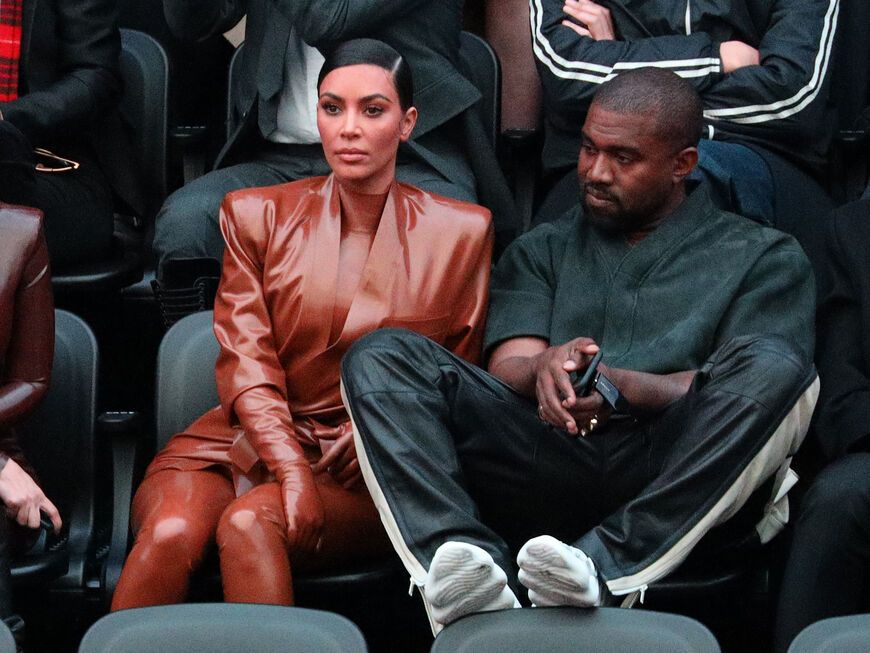 Kim Kardashian und Kanye West sitzen zusammen und sehen unglücklich aus