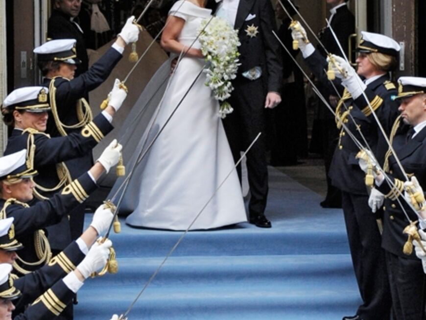 Das königliche Ehepaar verlässt den Stockholmer Dom. Victoria trug übrigens eine traumhafte Kreation aus cremefarbener Seide des schwedischen Designers Pär Engsheden. Ihr Diadem hatte schon ihre Mutter bei ihrer eigenen Hochzeit vor 34 Jahren getragen
