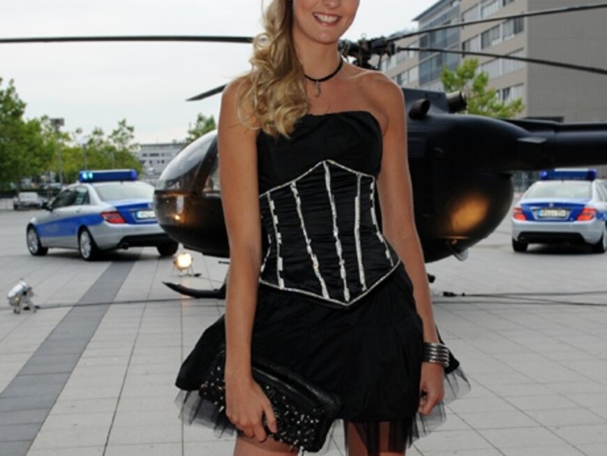 Model Miriam Höller posiert im zarten Sommerkleidchen vor einem Hubschrauber