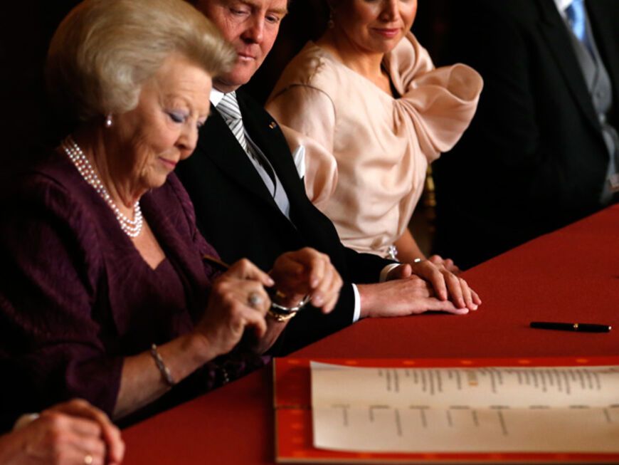 Ein emotionaler Moment, der Geschichte schreibt: Königin Beatrix unterschreibt am Dienstag, 30. April 2013, um 10.08 Uhr die Abdankungsurkunde. Es folgen Willem-Alexander und´  Máxima. Beatrix ist nun wieder Prinzessin - ihr Sohn der neue König und Máxima die Königin der Niederlande