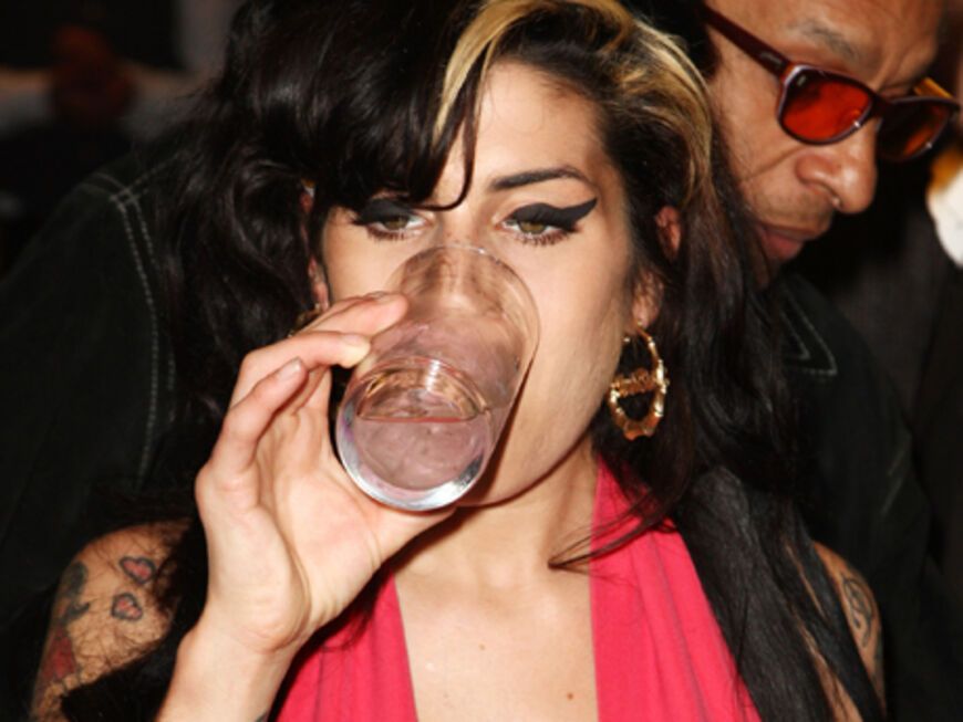 Amy Winehouse trinkt aus einem Glas