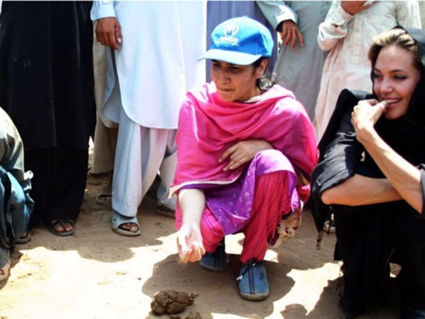 Angelina schaut einem Flüchtlings-Mädchen in Islamabad zu, wie sie Ziegelsteine anfertigt