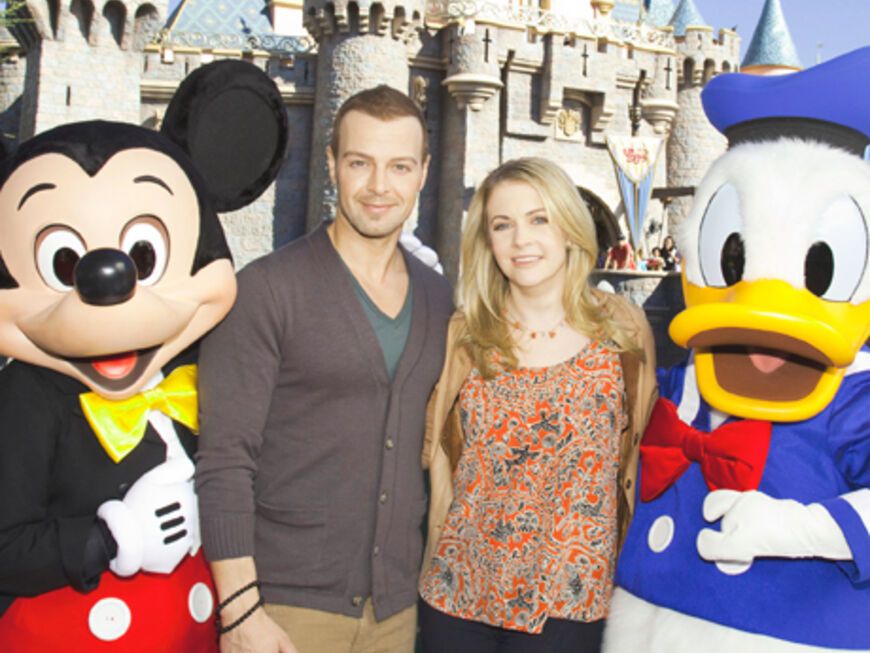 Bitte lächeln! Melissa Joan Hart und Joey Lawrence posieren vor dem großen Disney-Schloss mit Mickey Mouse und Donald Duck