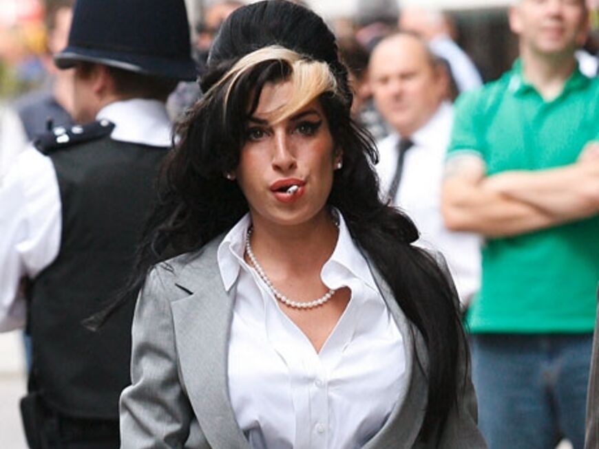 Mit weißer Bluse und gewohnter Bienenkorbfrisur erschien Winehouse vor Gericht