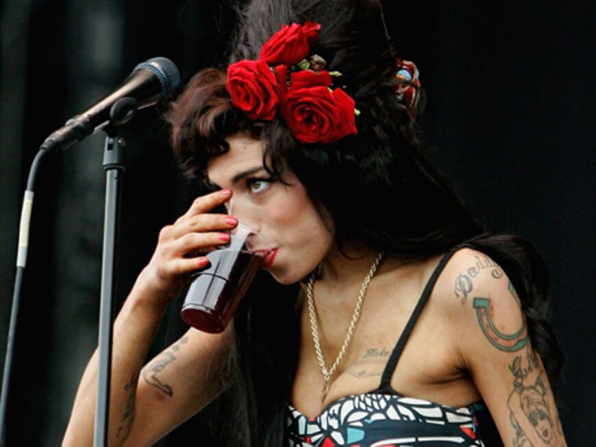 Amy Winehouse trinkt auf der Bühne