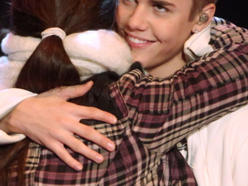 Justin Bieber umarmt einen Fan auf der Bühne