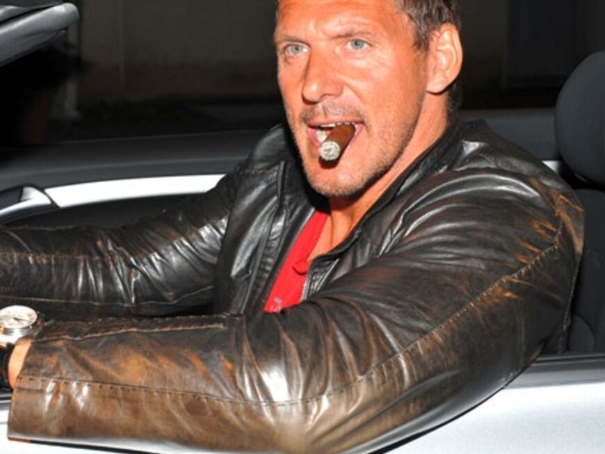 Actionheld Ralf Möller posiert mit Zigarre in einem Auto