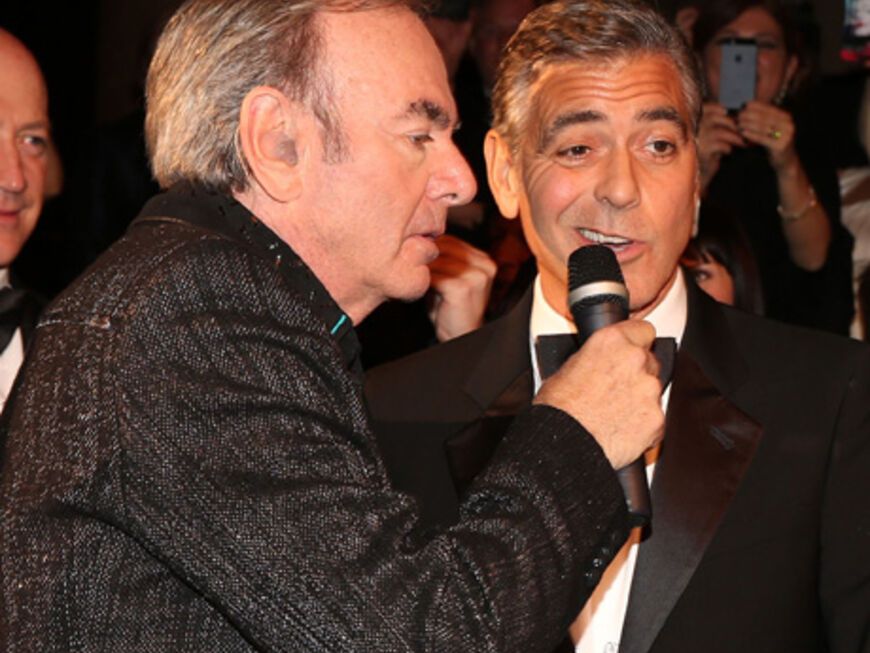 Erst kurzes Zögern bei George Clooney, der von Sänger Neil Diamond das Mikrofon an den Mund gehalten bekam ...