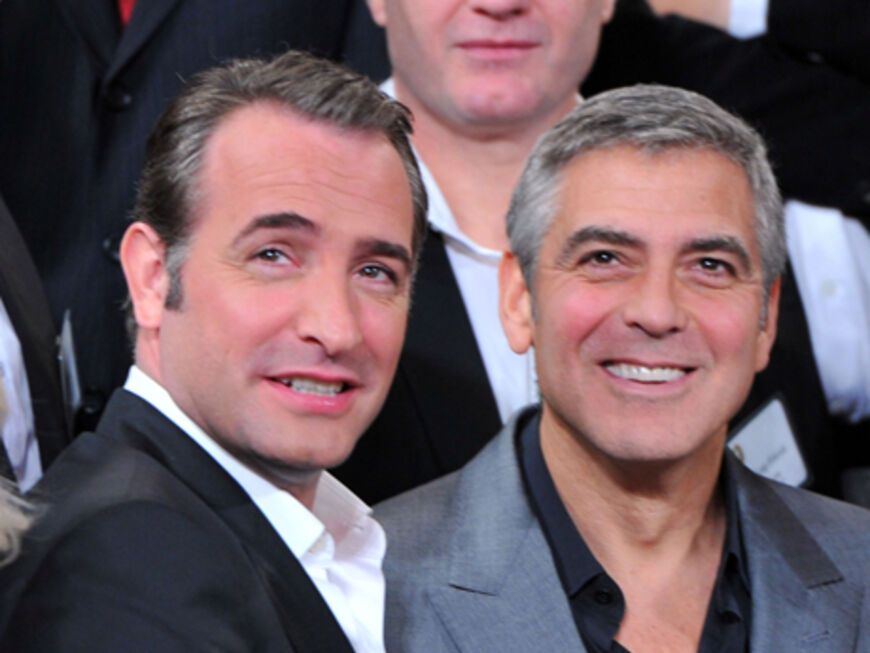 Jean Dujardin und George Clooney stellen sich für ein Foto auf
