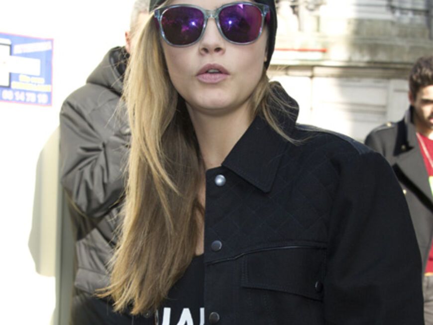 Hier gehört der Bad Hair Day zum Programm: Cara Delevingne trägt auf der Paris Fashion Week zu ihren glatten Haaren eine lässige Beanie-Mütze. Besonderes Highlight: die verspiegelte Sonnenbrille.