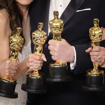 Vier Personen halten Oscar-Preise in den Händen