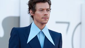 Harry Styles guckt ernst im blauen Anzug