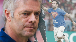 WM 2022: ARD-Kommentator Tom Bartels ernst - im Hintergrund Flitzer mit Regenbogen-Flagge