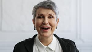 Frau mit kurzen, grauen Haaren lächelt