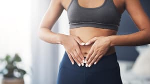 Frau formt Herz über Bauch