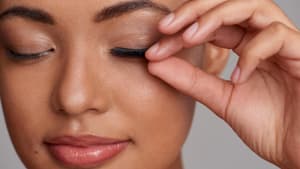 Frau fasst an Wimpern