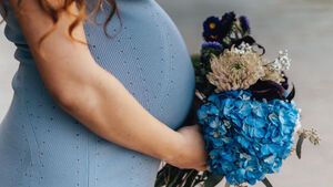 schwangere Frau mit Blumenstrauss