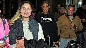 Yvonne Woelke lächelnd am Flughafen, Peter Klein im Hintergrund