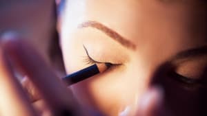 Frau schminkt sich mit Eyeliner 