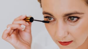 Frau schminkt sich mit Mascara 
