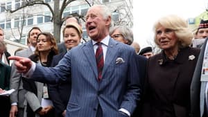 König Charles lacht auf dem Berliner Wochenmarkt, neben ihm steht Camilla