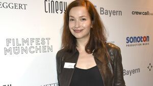 Uta Kargel lächelt vor einer Wand beim Filmfest München 2016