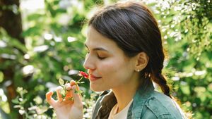 Frau riecht an einer Blume