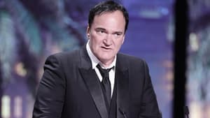 Quentin Tarantino steht mit ernstem Gesichtsausdruck am Mikrofon