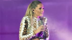 Helene Fischer steht mit Mikrofon auf der Bühne und schaut besorgt ins Publikum